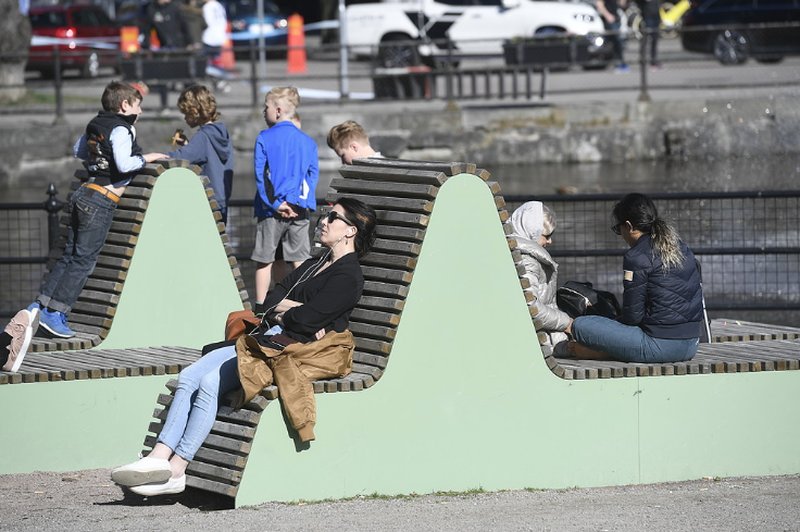 Folk som solar och leker vid en bänk Folk som solar och leker vid en bänk